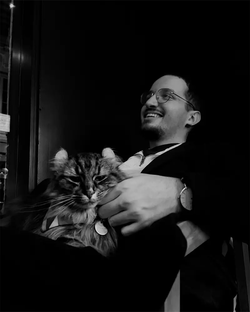 Photo de Jeyson Rous, souriant, caressant un chat